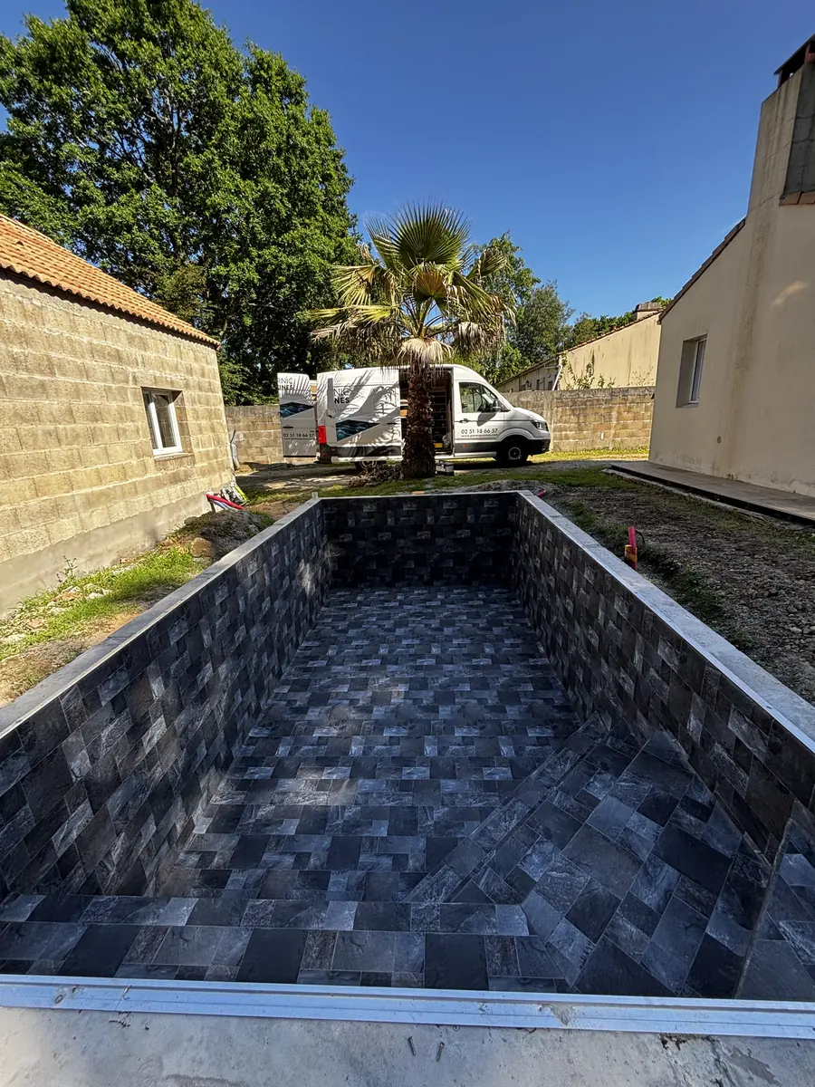 Bassin vide habillé d'un PVC armé aspect carrelage anthracite, avec son escalier d'angle